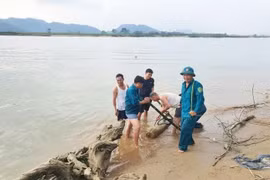 Authorities lift the bomb from the Lam River bank for disposal. (Photo: baomoi.com)