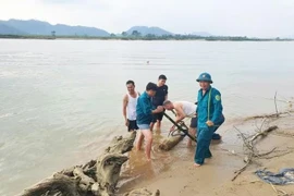 Authorities lift the bomb from the Lam River bank for disposal. (Photo: baomoi.com)