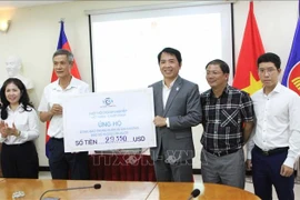 A representative of the Vietnam–Cambodia Business Association (VCBA) presents its donated fund to the leaders of the Vietnamese Ambassador to Cambodia Nguyen Minh Vu (2nd from left). (Photo: VNA)