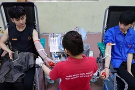 Young people donate blood at a voluntary blood donation event. (Photo: VNA)