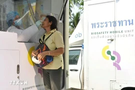 A health worker takes swab samples from a woman for a rapid antigen test in Bangkok, Thailand. (Photo: XINHUA/VNA)