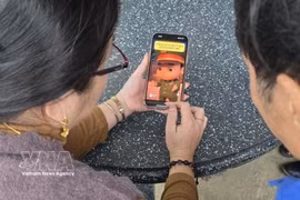 Residents are watching a short animated clip created using AI by the police in Bo Trach commune, Quang Tri province, to raise public awareness and provide warnings about crimes. (Photo: VNA) 