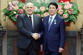 Vietnamese State President Luong Cuong (R) shakes hands with Russian Prime Minister Mikhail Mishustin. (Photo: VNA)