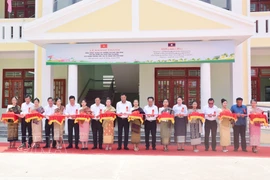 Representatives from both countries cut the ribbon to inaugurate the Friendship Primary and Secondary School in Salavan province of Laos (Photo: VNA)