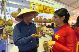 Canadian visitor Nigel Miranda expresses his impression of Vietnamese bamboo and rattan products at the Malaysia Entrepreneurs Day 2025. (Photo: VNA)