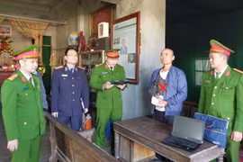A policeman reads an order to detain Le Minh Vu (Photo: VNA)