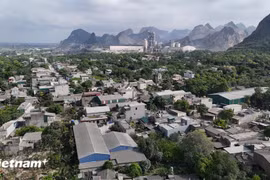 A residential area covered by smoke and dust caused by stone mining and cement production activities. (Photo: VietnamPlus)