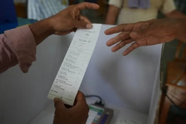 Officials of the Union Election Commission show a test slip from an electronic voting machine as they prepare to set up a polling station at a school in Yangon, Myanmar, one day ahead of the first phase of the general election, Saturday, December 27, 2025. (Photo: AFP)