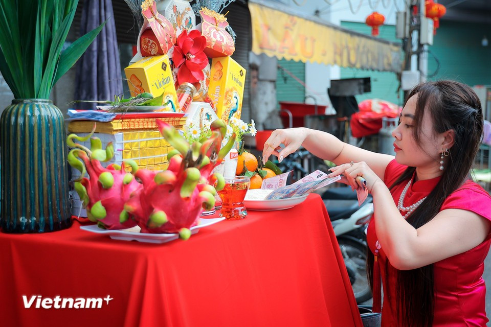 Before the sacred procession begins, villagers prepare offerings outside their homes to pay respects as the palanquin passes by. (Photo: VietnamPlus)