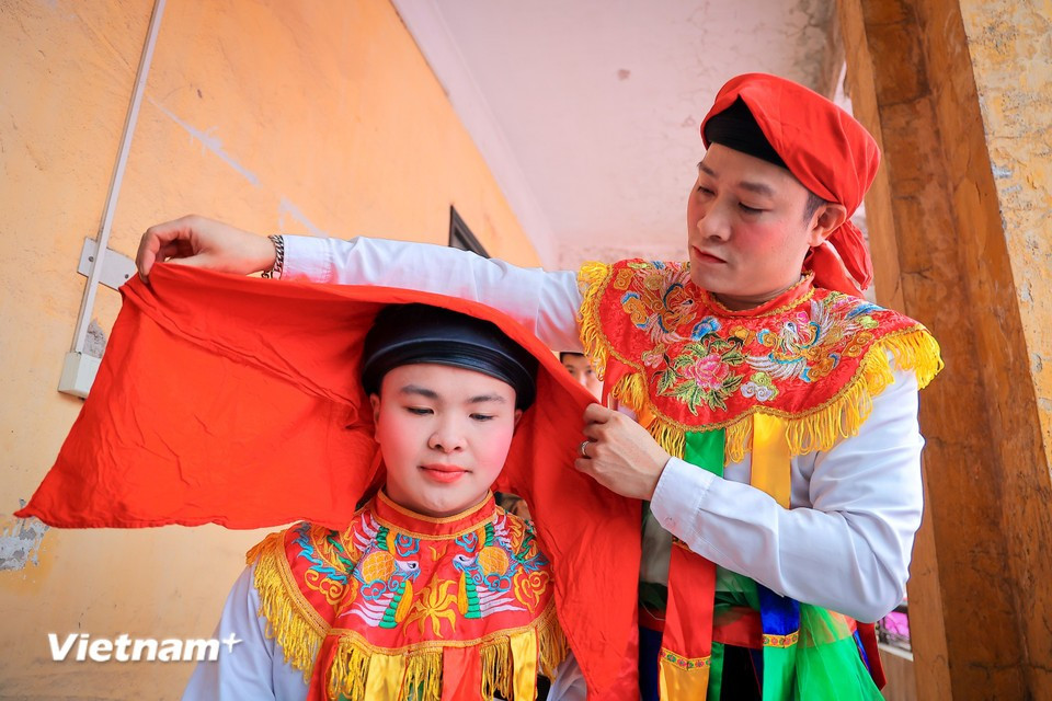 Young men dress as women and apply colourful makeup before performing the Bong dance during the sacred procession. (Photo: VietnamPlus)