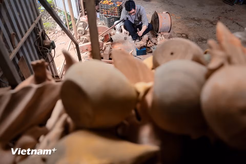 The artisan uses local materials from the Doai region such as jackfruit wood, bamboo, and especially laterite – a signature material shaping the architectural identity of Duong Lam ancient village – to create the sculptures. (Photo: VietnamPlus)