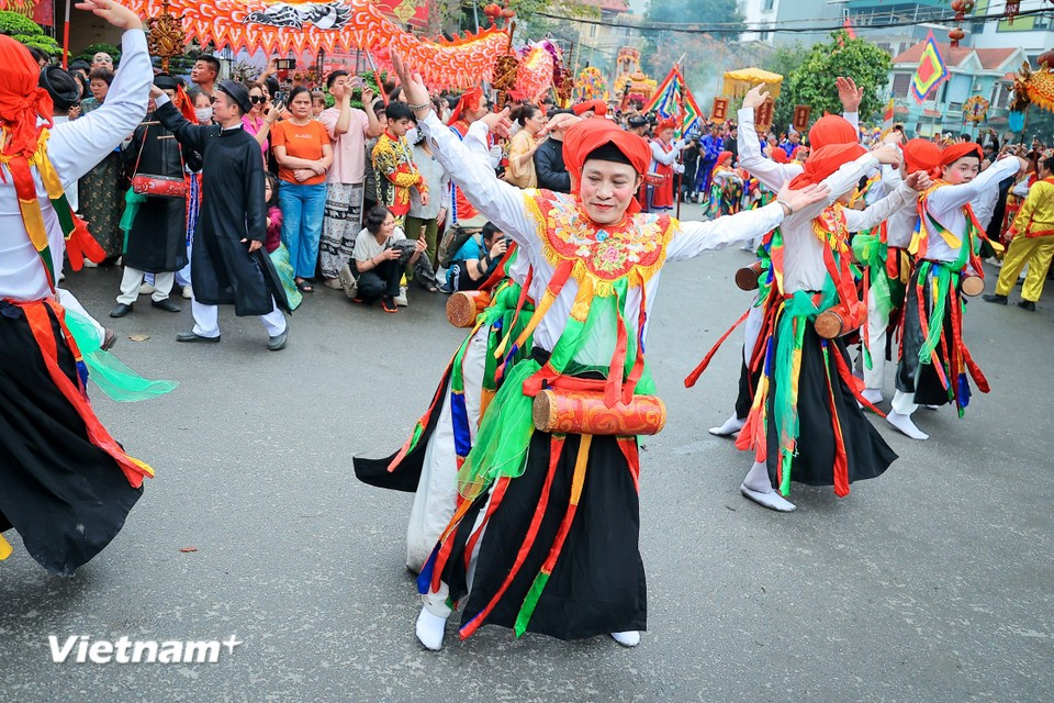Wearing makeup and female costumes with drums strapped to their chests, performers execute lively and flirtatious dance movements together. (Photo: VietnamPlus)