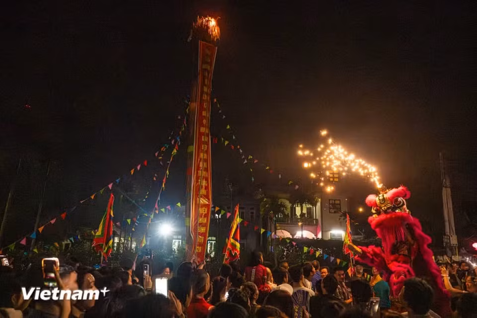 The sounds of gongs and drums echoed joyfully, flags filled the sky, and festive excitement spread through the village lane. (Photo: VietnamPlus)