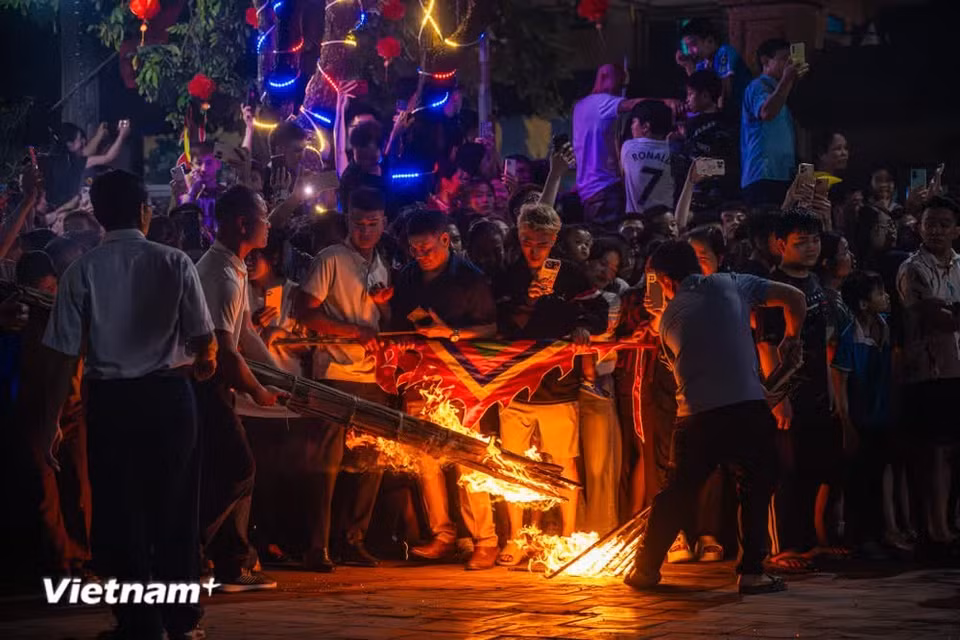 Festivalgoers gathered joyfully under the glow of the torches, all hoping to pass beneath the palanquin to pray for blessings and good fortune. (Photo: VietnamPlus)
