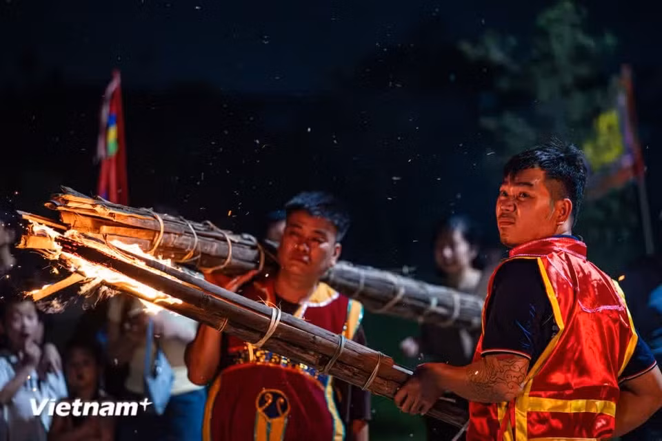 Wherever the Saint goes, the torches burn brightly as if lighting his path. Though the night is pitch-black, the four giant torches illuminate the entire area. (Photo: VietnamPlus)