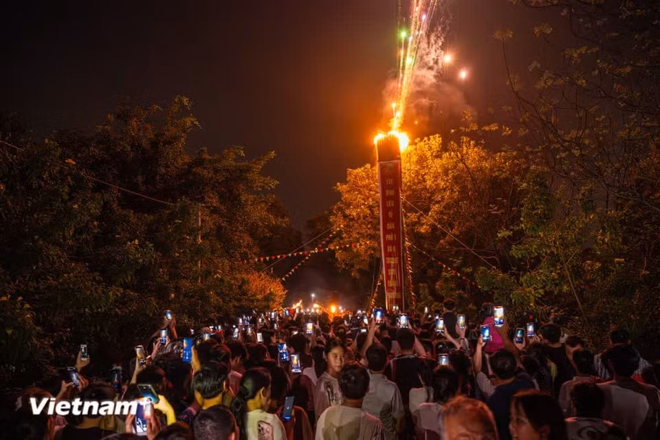 Following ancient customs, on the morning of the 14th day of the first lunar month, villagers joyfully escort the Saint from Tuong Phieu communal house to Ngo Son Temple (Ngo Temple) amid the sound of drums. After the fire-taking and fire-lighting rituals, four giant torches are ignited, illuminating the night sky over Tuong Phieu. (Photo: VietnamPlus)