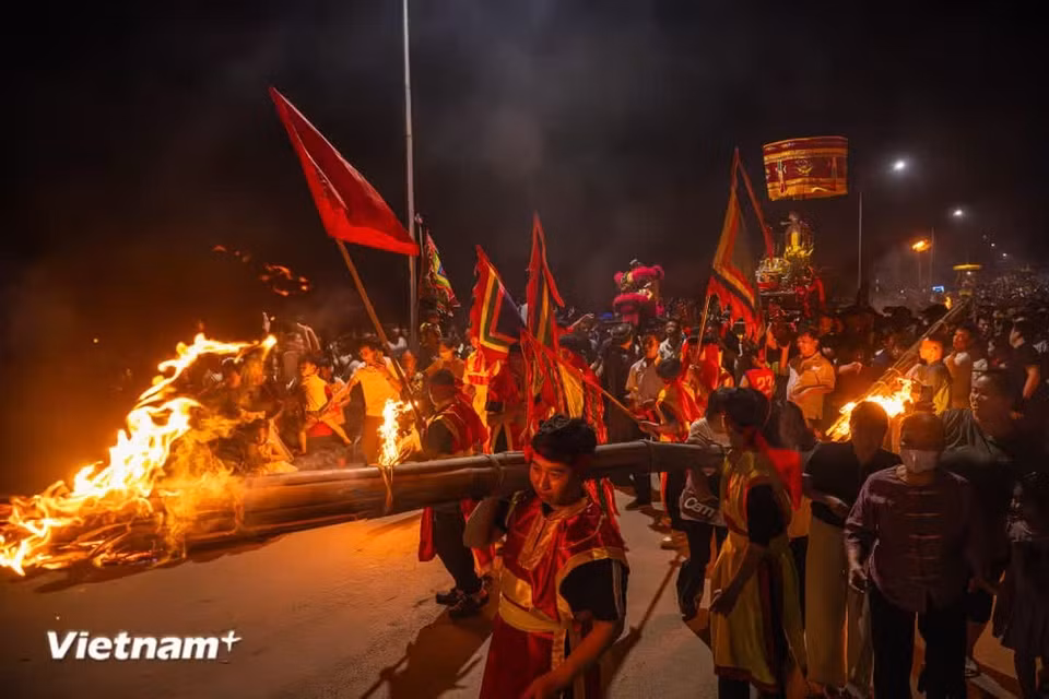 At around 20:00 on the 14th day of the first lunar month, villagers begin lighting the torches while carrying the Saint’s palanquin from Ngo Temple back to the communal house. (Photo: VietnamPlus)