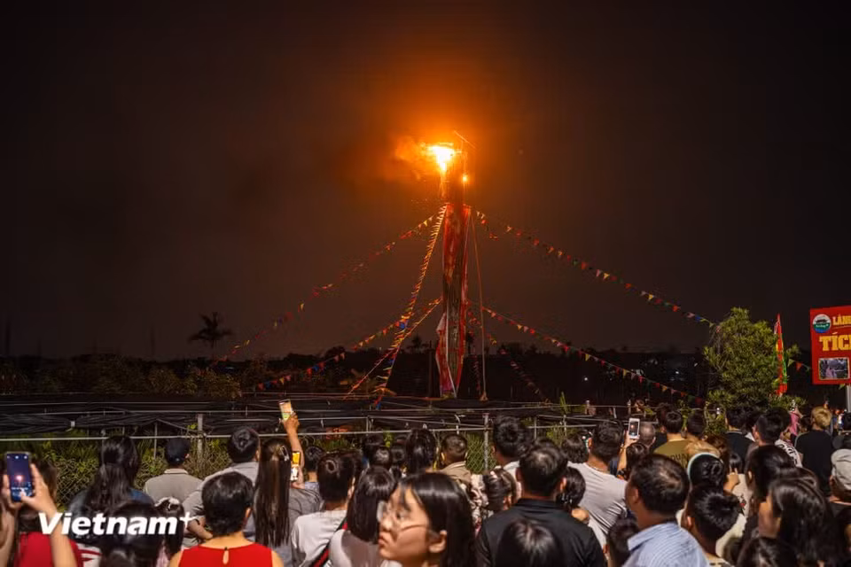 In the darkness, villagers light four giant bamboo torches, as tall as a three- or four-story building, to guide the Saint’s procession from the temple back to the communal house. (Photo: VietnamPlus)