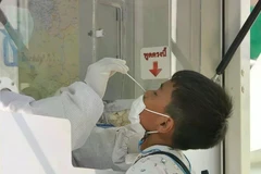 A medical worker takes COVID-19 sample for a citizen in Bangkok (Photo: Xinhua/VNA)