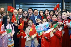 Prime Minister Pham Minh Chinh and his spouse, with Vietnamese Embassy staff and community in Algeria. (Photo: VNA)