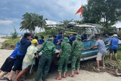 Youth union members in Lien Chieu district, Da Nang city, assist residents in bringing a basket boats ashore before a storm in October 2024. (Photo: VNA) 