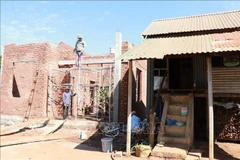 A new house is gradually being completed next to the old home of Ksor's family, a poor household in Mai Village, Ia Hrung commune, Gia Lai. (Photo: VNA)