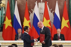 Party General Secretary To Lam and President Vladimir Putin witness Vietnamese Deputy Prime Minister and Minister of Foreign Affairs Bui Thanh Son (L) and Russian Deputy Prime Minister Dmitry Chernyshenko exchange the agreement on cooperation in the oil and gas sector and protocols governing the operations of the Vietsovpetro and Rusvietpetro joint ventures. (Photo: VNA)