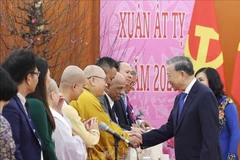 Party General Secretary To Lam (R) and participating overseas Vietnamese representatives at their meeting in Hanoi on January 19. (Photo: VNA)