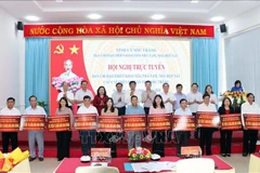 Soc Trang leaders and sponsors present representatives of localities involved tokens of the second phase of funding for the provincial programme to do away with 8,452 temporary and dilapidated houses by September 30 next year. (Photo: VNA)