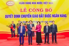 Nguyen Thi Hong, Governor of the State Bank of Vietnam, hands over the decision on the mandatory transfer of DongA Bank to Kim Byoungho, Chairman of the Board of Directors of HDBank in Hanoi on January 17. (Photo courtesy of HDBank)