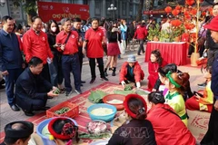 Making banh chung (Vietnam’s traditional square glutinous rice cake) at the Hanoi Red Cross Society's charity market on January 4. (Photo: VNA)