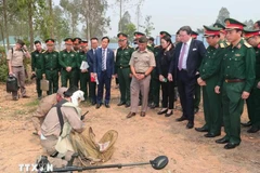 Delegates participnating the ceremony observe a demonstration of preparatory procedures before conducting bomb and mine clearance operations. (Photo: VNA) 