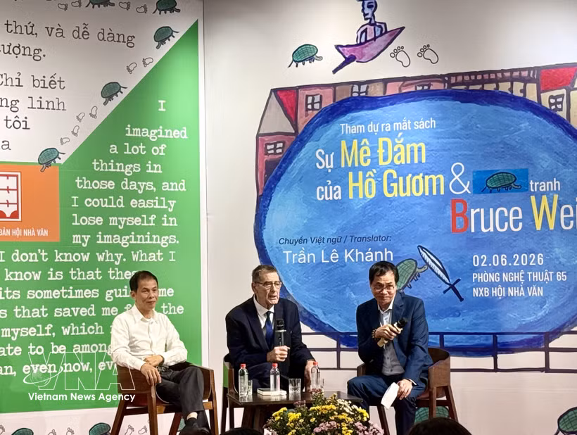 American poet Bruce Weigl (centre), translator Tran Le Khanh (left), and poet Huu Viet talks with readers at the book launch and art exhibition in Hanoi on June 2. (Photo: VNA)