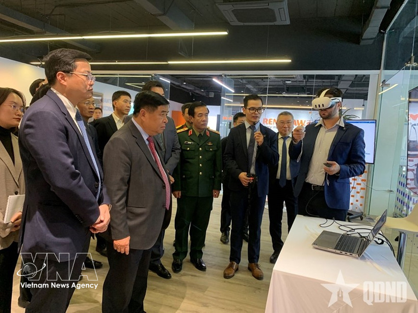 Deputy Prime Minister Nguyen Chi Dung and other delegates are briefed on R&D centre and COE on AI and Digital Twin at NEC. (Photo: VNA) 