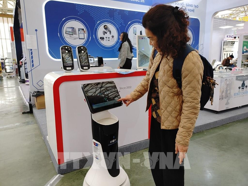 A visitor experience the robot receptionist at the Spring Fair 2026. (Photo: VNA)