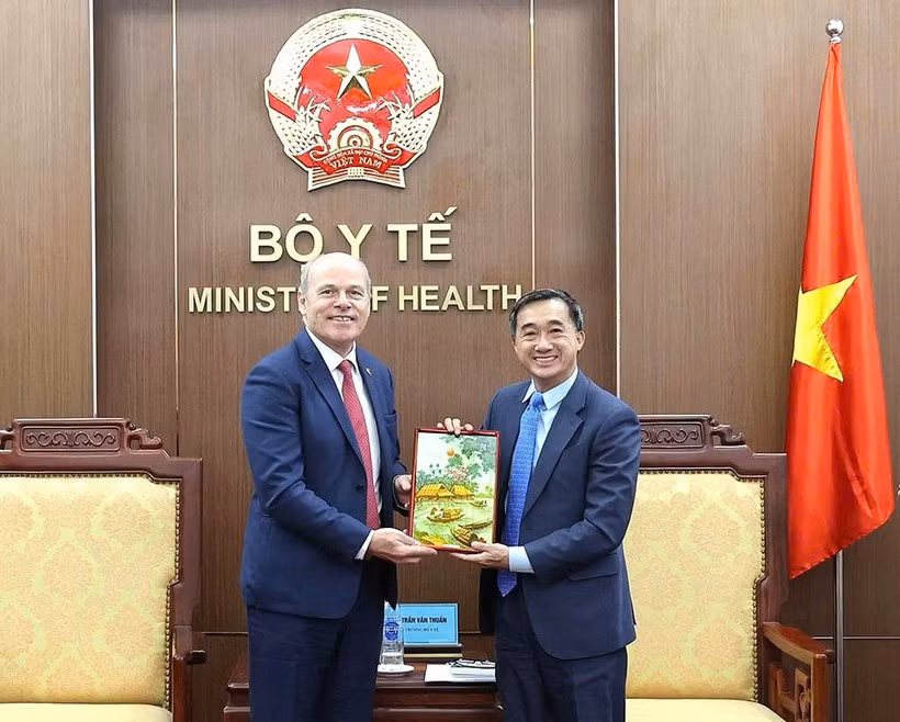 Deputy Minister of Health Tran Van Thuan (right) presents a souvenir to Canadian Ambassador to Vietnam James Nickel at the meeting on March 13. (Photo: T.M)