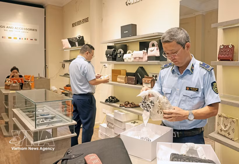 A market surveillance team carries out an unannounced inspection at a fashion business in Hanoi. (Photo: VNA)