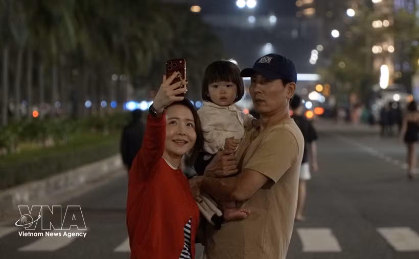 A Korean tourist family poses for a photo in the coastal city of Da Nang. (Photo: VNA)