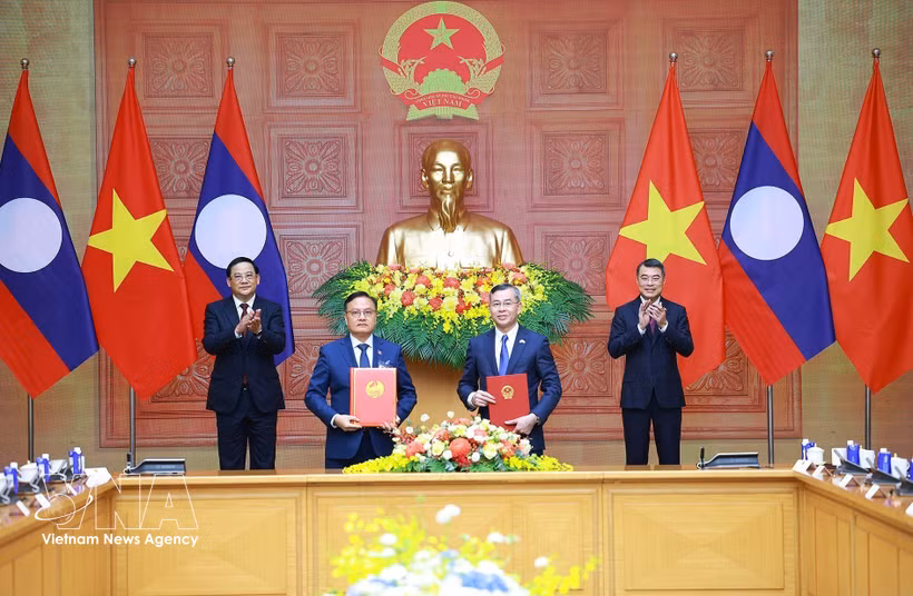 Vietnamese Minister of Finance Ngo Van Tuan (R) and Lao Deputy Prime Minister and Minister of Finance Santiphab Phomvihane exchanges a cooperation agreement between their respective ministries for the 2026–2030 period under the witness of Vietnamese Prime Minister Le Minh Hung (R) and his visiting Lao counterpart Sonexay Siphandone in Hanoi on June 7, 2026. (Photo: VNA).