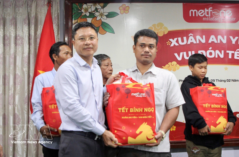 Leaders of the Vietnamese Embassy in Cambodia and Metfone present Lunar New Year gifts to people of Vietnamese origin in Phnom Penh. (Photo: VNA)
