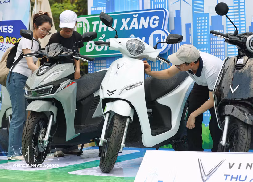 Visitors to an exhibition and test-drive programme for electric vehicles organised in Cau Giay ward, Hanoi, on May 16 by the municipal People's Commitee and relevant agencies. (Photo: VNA)