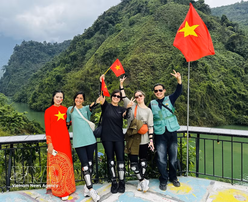 Foreign tourists in a photo with local residents. (Photo: VNA)