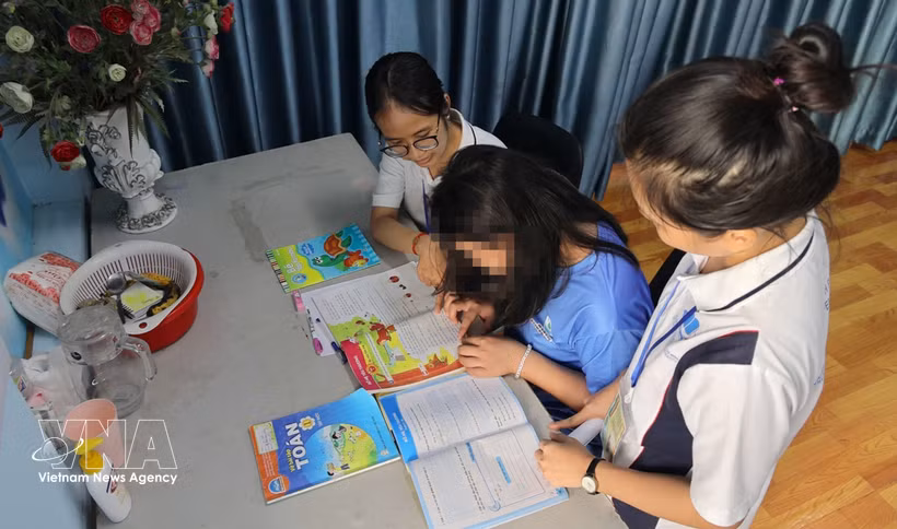 Social workers assist T.A.T. (born in 2013) with studying and daily activities at the temporary shelter of the “Bo Cong Anh” model in Hanh Thong ward, Ho Chi Minh City. (Photo: VNA)