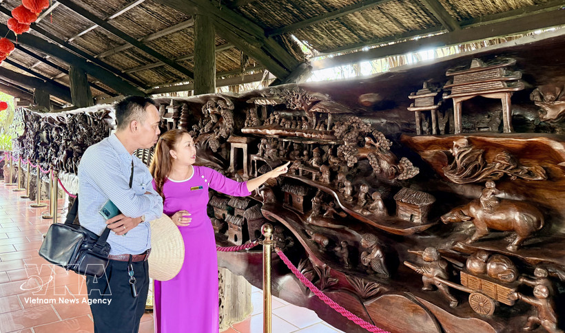 Visitors admire a large driftwood sculpture measuring nearly 25 metres in length and weighing around 20 tonnes, regarded as one of the most intricate works of its kind in Vietnam. (Photo: VNA)