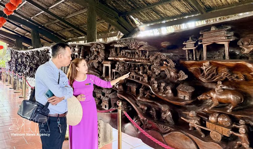 Visitors admire a large driftwood sculpture measuring nearly 25 metres in length and weighing around 20 tonnes, regarded as one of the most intricate works of its kind in Vietnam. (Photo: VNA)