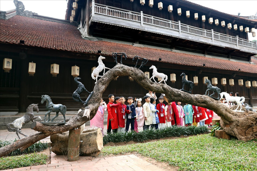Children enjoy the “Horses come to the city” exhibition at the Temple of Literature in Hanoi. (Photo: VNA)