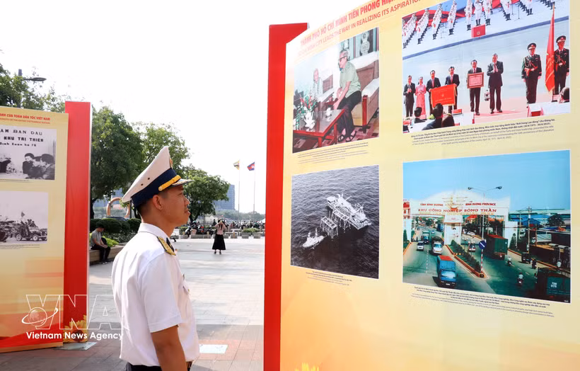 A visitor looks at photos featuring people and landscape of Vietnam (Photo: VNA)