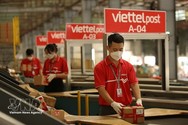 Workers classify packages at a warehouse of Viettel Post. (Photo: VNA)