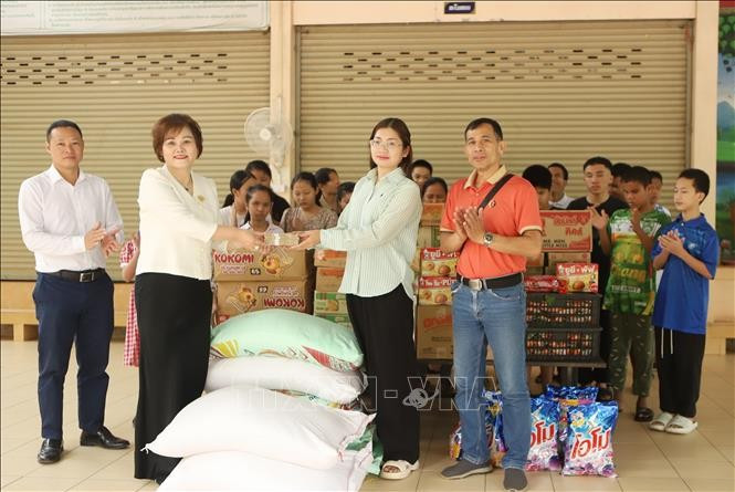 Pham Thi Minh Huong (second, left), Chairwoman and General Director of Gold Phuc Company, presents gifts to students at the school for the visually impaired under Thongpong Eye Hospital in Sikhottabong district, Vientiane capital, on February 28 (Photo: VNA)
