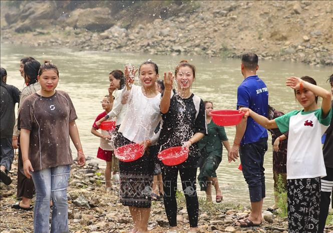 Young Lao ethnic women splash water to pray for good fortune during the traditional water-splashing New Year festival. (Photo: VNA)